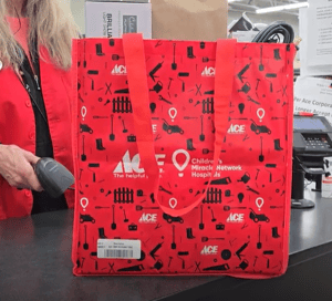 Ace Hardware reusable carry bag being scanned at checkout, supporting Children's Miracle Network Hospitals