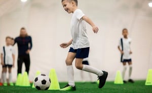 A group of young kids doing football training with a ball